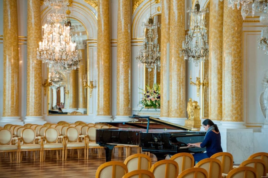 Pianist performing under chandeliers in Warsaw.
