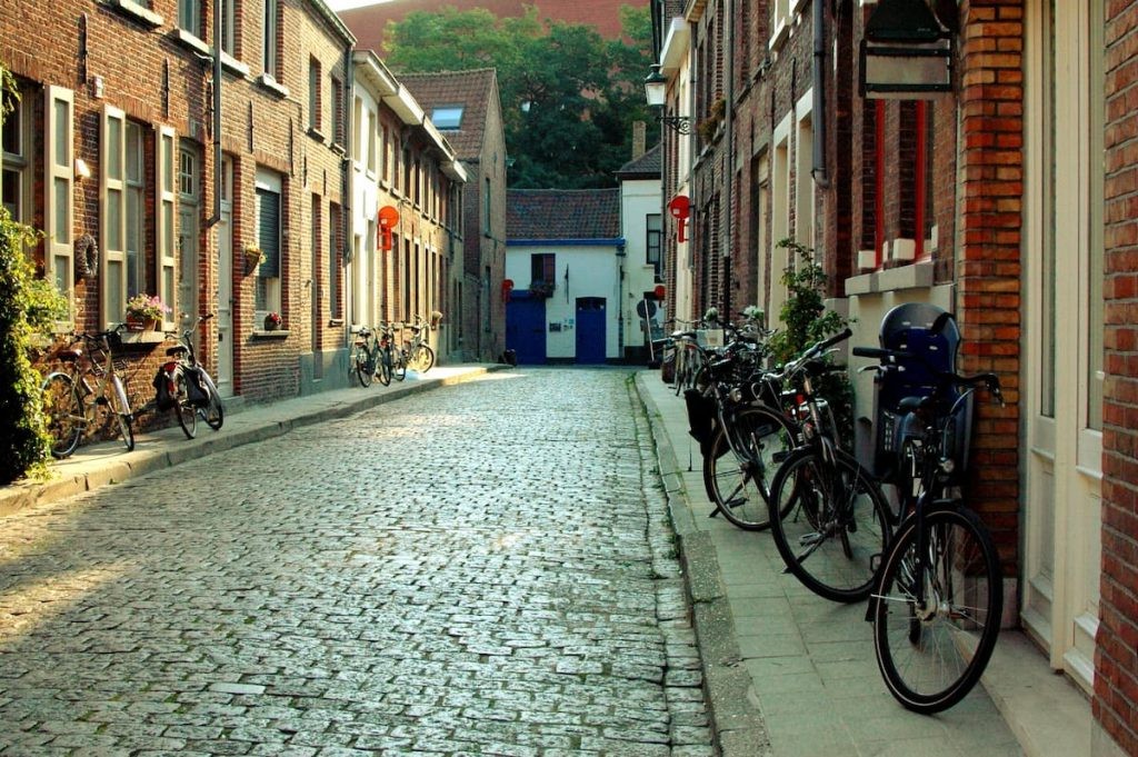 Quiet cobblestone street lined with bicycles and brick houses