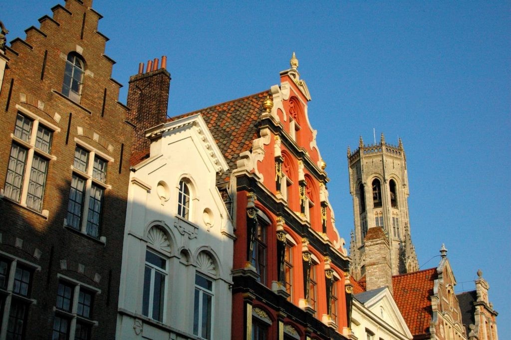 Colorful gabled buildings with the Belfry rising behind