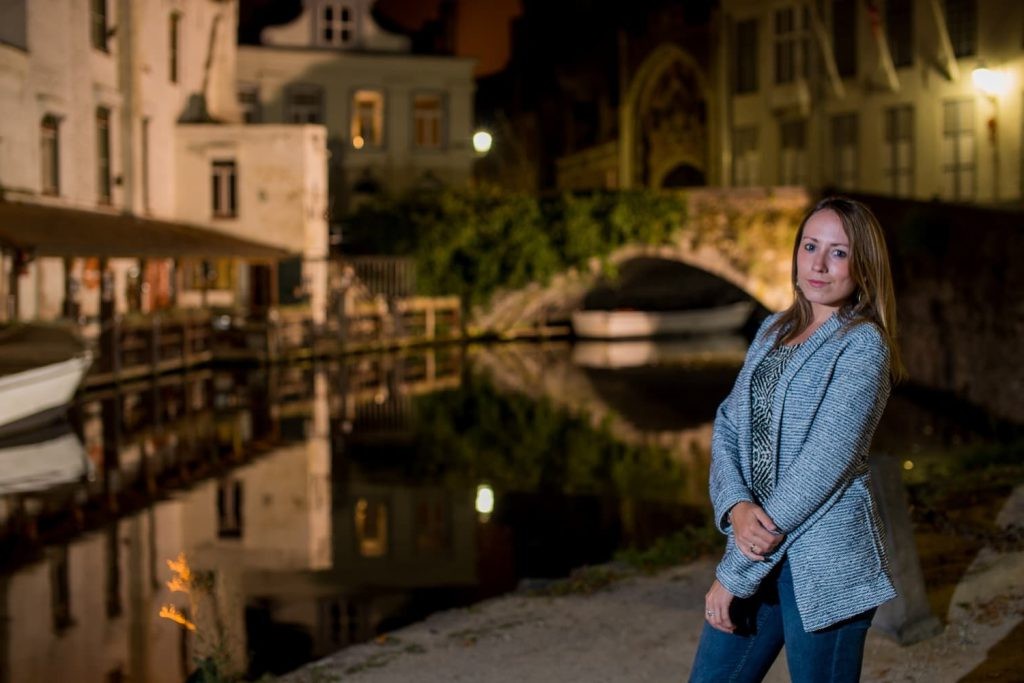 Evening canal scene with warm lights and a stone bridge