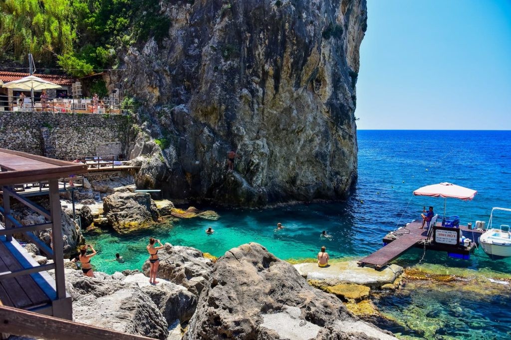 Sunbathers and swimmers at La Grotta Beach Bar in Paleokastritsa