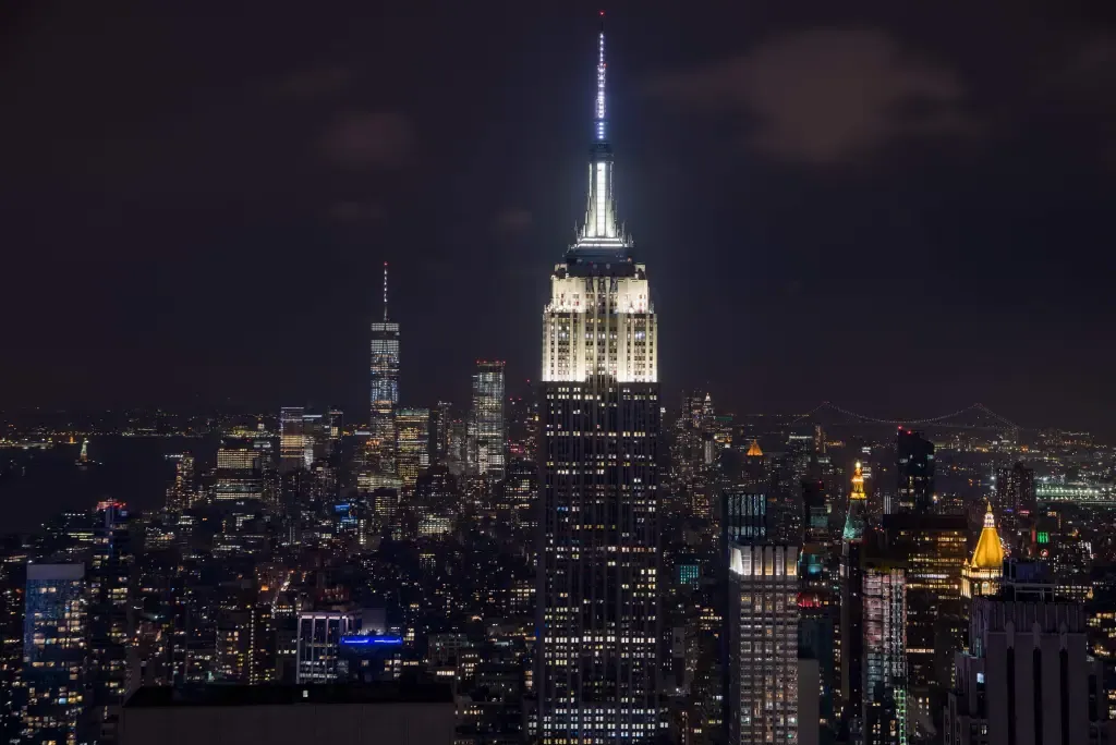 Night view of the NYC skyline with the Empire State Building front and center.
