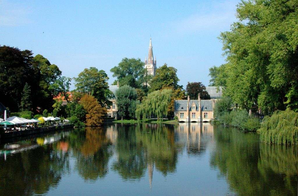 Minnewater Park lake with café terrace and church spire in the distance
