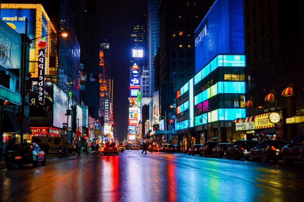 Times Square after rain with neon reflections across the street.
