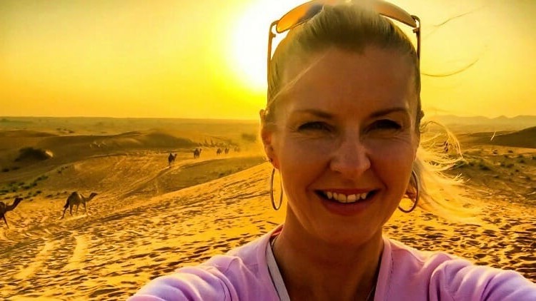 Selfie in the Dubai desert with camels at sunset